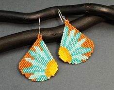 a pair of beaded earrings on top of a branch