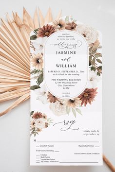 an elegant wedding program with flowers on the front and back, surrounded by bamboo fans