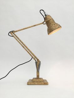 a lamp that is sitting on top of a wooden base and has a light attached to it