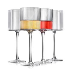 three wine glasses with different colored liquids in them