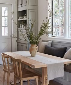 a vase with some flowers sitting on top of a table in a living room next to a couch