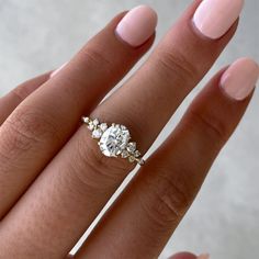 a woman's hand with a three stone ring on top of her left hand