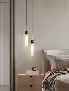 a bedroom with a bed, nightstand and two lights hanging from the ceiling above it