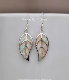 "Sweet new earrings made using white opal and silver. They feature small leaf charms, set with inlaid white opal gemstones. The opal is white, with great rainbow fire. They are accented with silver plated metal along the \"veins\" and edges of the leaves. Leaves are 7/8\" long and hang from Sterling silver french hooks. Total earring length is 1 1/2\" long. Please contact me if you prefer a different ear wire (hoop, lever back, etc) for details and pricing. * Nickel and lead free ** SEE ROSE GOL White Opal Earrings For Pierced Ears, Handmade White Leaf-shaped Jewelry, White Leaf-shaped Earrings With Ear Wire, White Leaf-shaped Jewelry Gift, White Opal Drop Earrings, Small Dangle Earrings, Rainbow Fire, Rainbow Roses, Autumn Nature