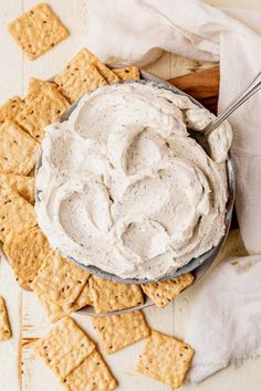 a bowl filled with cream cheese surrounded by crackers