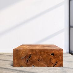 a wooden table sitting on top of a floor next to a window in a room