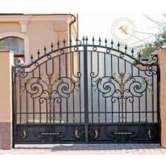 an iron gate is shown in front of a house