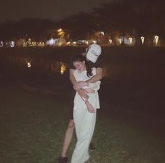 a man holding a woman in his arms at night