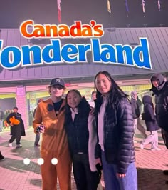 three people standing in front of a building with the words canada's wonderland on it