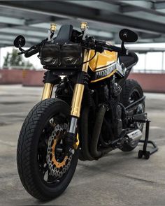 a yellow and black motorcycle is parked in a parking lot with no one around it