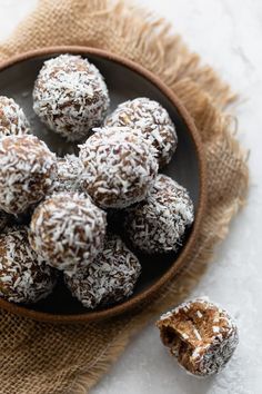 chocolate coconut date balls in a bowl on a table with the title text above it