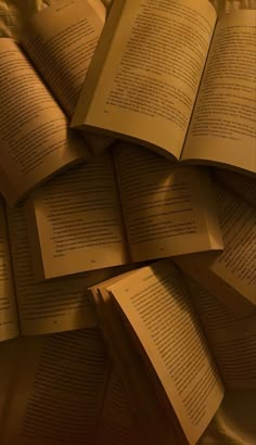 a pile of open books sitting on top of each other