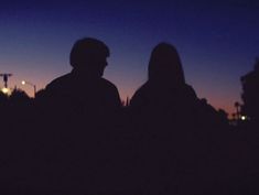 two people standing in the dark at night