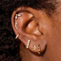 a close up of a person with ear piercings on their ears and behind the ear