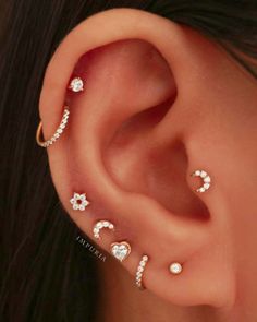 a woman's ear with three different piercings