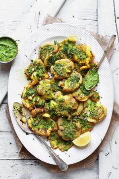 a white plate topped with potatoes covered in pesto