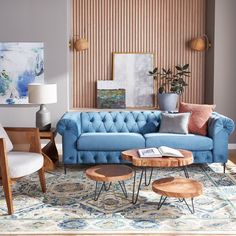 a living room with blue couches and wooden tables in it's center area