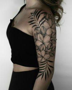 a woman's arm with flowers and leaves on it