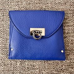 This Salvatore Ferragamo Wallet Is A Triumph Of Style And Design. Finished In Textured Bright Blue Leather, This Wallet Folds Out To Reveal Many Card Pockets And Long Pockets For Cash. This Is Secured By A Silver-Tone Twist Lock. The Back Pocket Opens To An Accordion Fold Compartment. Exterior Material Leather Interior Material Nylon Length 5” Width 0.39” Height 4” Hardware Silver Tone Tri Fold Wallet, Ferragamo Wallet, Accordion Fold, Fold Wallet, Trifold Wallet, Tri Fold, Leather Interior, Bright Blue, Blue Leather