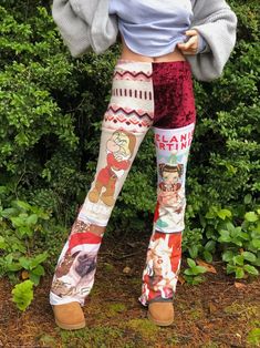 a woman standing in front of some bushes wearing leggings with pictures on them