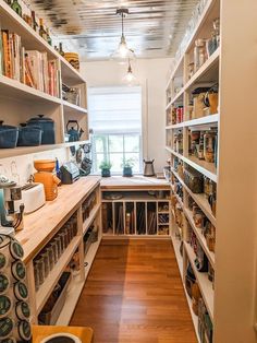 a kitchen with lots of shelves filled with food and cooking utensils on top of wooden flooring