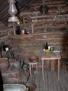 an old fashioned kitchen with wooden walls and flooring is pictured in this image,