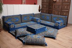 a living room with blue couches and rugs on the wooden floor next to a potted plant