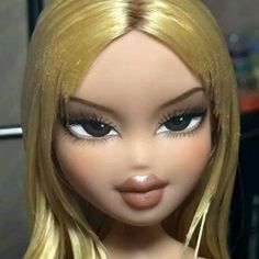 a close up of a doll with blonde hair