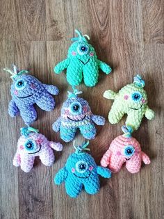 six crocheted stuffed animals sitting on top of a wooden floor