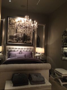 a bedroom with a chandelier hanging from the ceiling and a bed in front of it