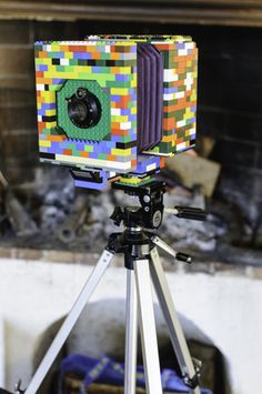 an old camera on a tripod in front of a fire place