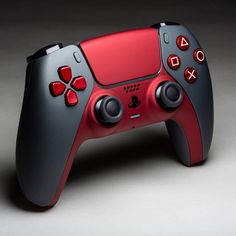 a red and black controller on a gray background