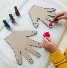 a child is cutting out paper with scissors and glues on the table next to some crafting supplies