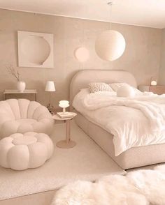 a large white bed sitting in a bedroom next to a chair and table with two lamps on it