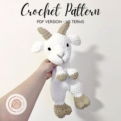 a hand holding a crochet stuffed animal in the shape of a goat with horns