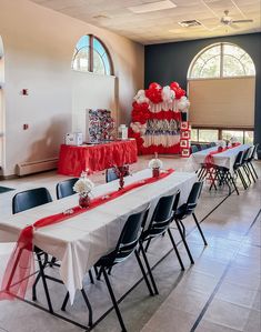 a long table with red and white decorations on top of it in a large room