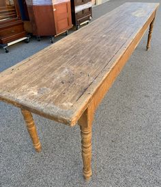 an old wooden table sitting on top of a carpeted floor