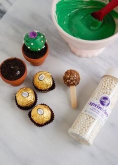 cupcakes and candy on a marble counter with green icing in the background