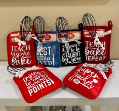 four red and blue bags with the words best teacher ever on them are sitting on a table