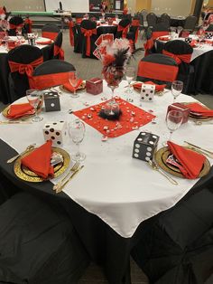 a banquet table set up with red and black napkins