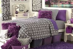 a bedroom with purple and black decor on the walls, bedding and rugs