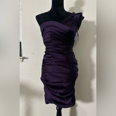 Elevate Your Style With This Stunning Vera Wang Lavender Label Dress. The One-Shoulder Design, Sleeveless Cut, And Sheath Style Create A Sleek And Sophisticated Look That Is Perfect For Any Formal Or Cocktail Occasion. The Dress Features A Beautiful Solid Purple Color And A Short Length That Adds A Touch Of Playfulness To Its Elegance. The Zipper Closure Ensures A Comfortable And Secure Fit, While The Brand's Reputation For Quality Gives You Peace Of Mind That You Are Purchasing A Garment That W Purple Sleeveless One Shoulder Dress For Evening, Purple Mini Dress With Ruched Bodice, Purple Sleeveless Mini Dress With Ruched Bodice, Purple Ruched Bodice Dress For Cocktail, Purple Ruched One-shoulder Dress, Purple Strapless Cocktail Dress, Purple Cocktail Dress With Ruched Bodice, Purple Strapless Formal Mini Dress, Purple Strapless Dress For Formal Occasions