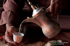 a person pouring tea into a cup