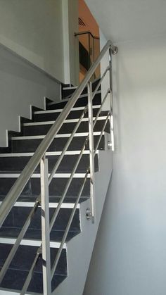 a white stair case next to a wall