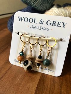 the wool and grey keychain has four charms hanging from it's hooks