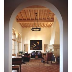 an archway leading to a living room filled with furniture and paintings on the walls,