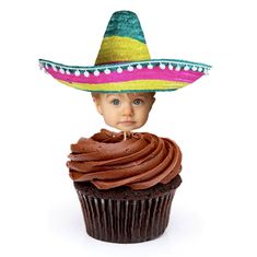 a little boy wearing a sombrero sitting on top of a cupcake with chocolate frosting