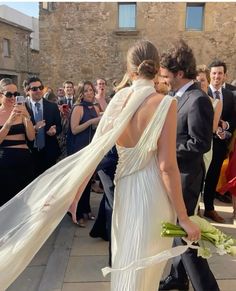 a man in a suit and tie standing next to a woman in a white dress