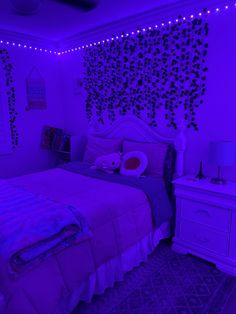 a bed room with a neatly made bed and purple lights on the wall above it