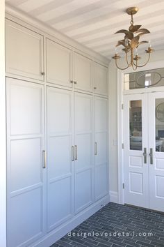 a room with white cabinets and a chandelier